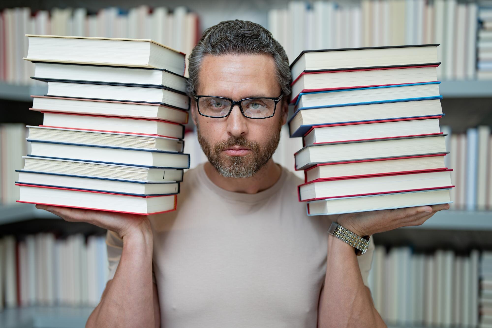 Portret nauczyciela w klasie bibliotecznej Nauczyciele w bibliotece uniwersyteckiej Dzień Nauczycieli Zabawny nauczyciel trzyma wiele książek Szalony nauczyciel z książkami Podekscytowany nauczyciel w szkolnej bibliotece książek