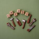 Narzędzia i napisy symbolizujące naprawy lub garaż i jego atrybuty na prostym tle