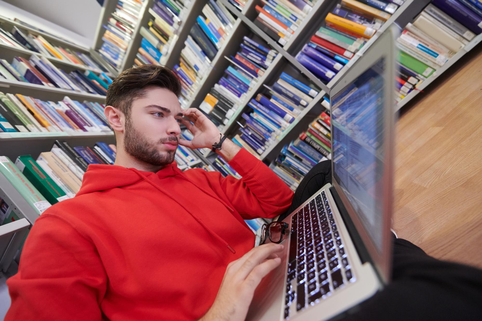 uczniowie używają laptopa i szkolnej biblioteki