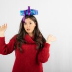 Portret zdziwionej dziewczyny zakładającej pudełko na głowę.