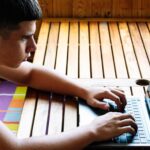 Skoncentrowane dziecko korzystające z laptopa